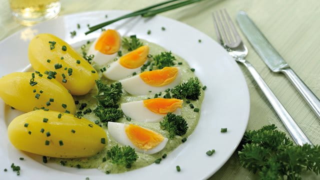 Teller mit grüner Soße, Kartoffeln und hartgekochten Eiern