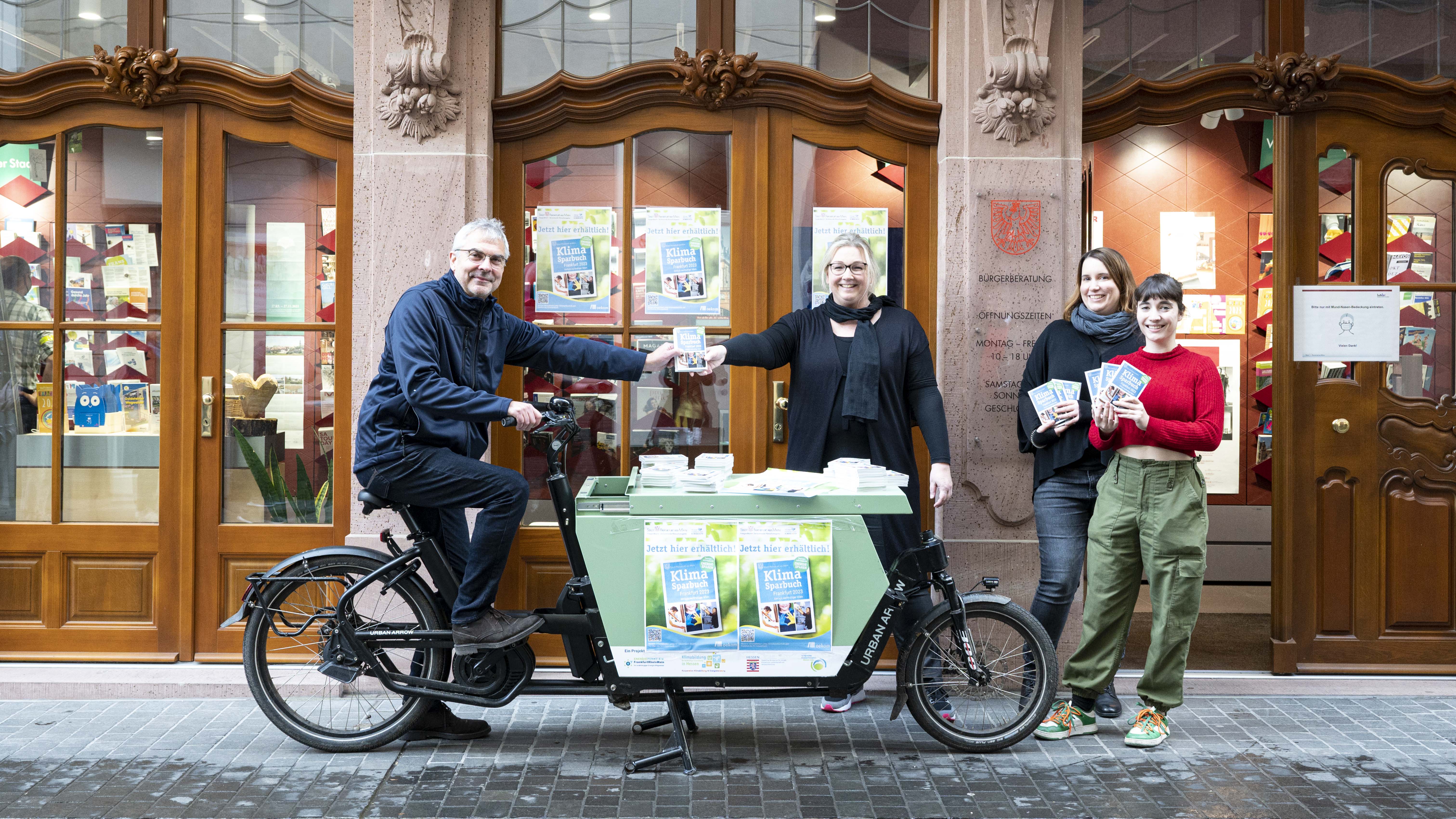 Übergabe des Klimasparbuchs 2023 mit Lastenrad vor der Bürgerberatung in der Frankfurter Altstadt.