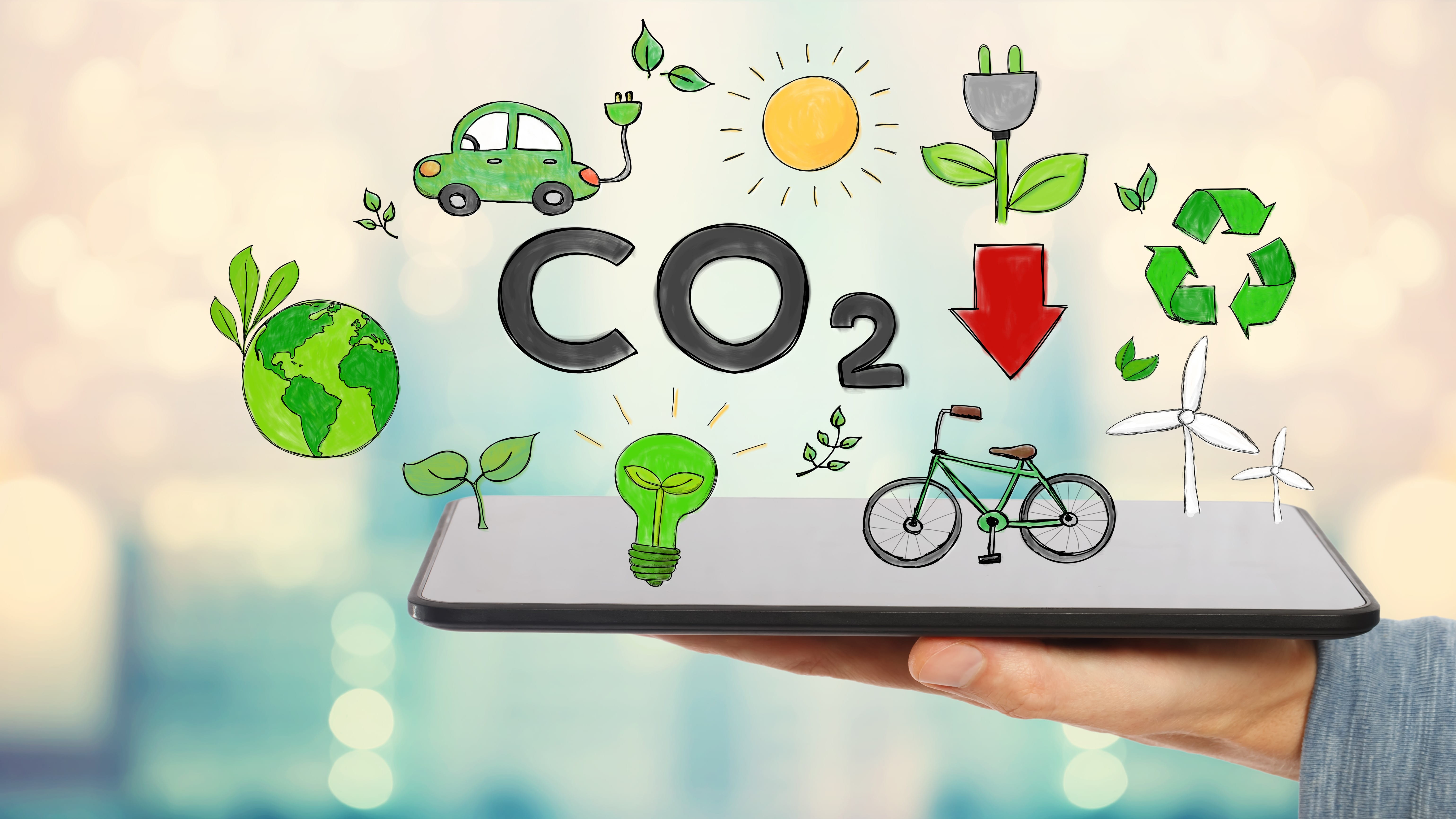 Mann hält einen Tablet-PC, darüber schweben verschiedenen Symbole für Einsparungsmöglichkeiten von CO2 wie Elektroauto, Windrad und weitere sowie die Buchstaben CO2 mit einem Pfeil nach unten.
