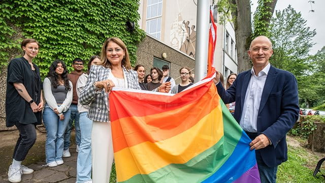 Bürgermeisterin Nargess Eskandari-Grünberg und Schulleiter Gerrit Ulmke hissen die Regenbogenflagge an der Helmholtzschule; Foto: Holger Menzel