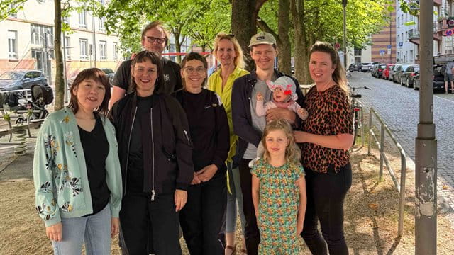 Das Team Rottweiler Straße 7 Erwachsene, ein Baby und ein Kind stehen vor der Rottweiler Straße, Foto: privat