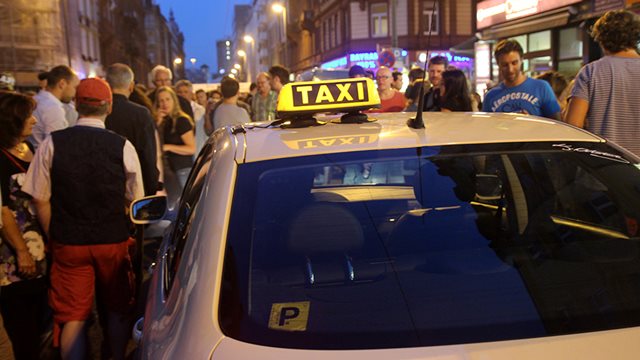 Ein Taxi steht während der Bahnhofsviertelnacht auf der Straße in einer Menschenmenge, Foto: Stefan Maurer