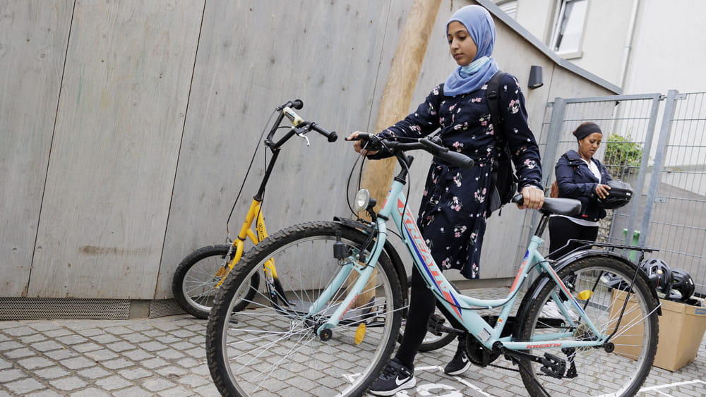 Noorsaba schiebt ihr Fahrrad zum Übungsplatz, Foto: Stefanie Kösling