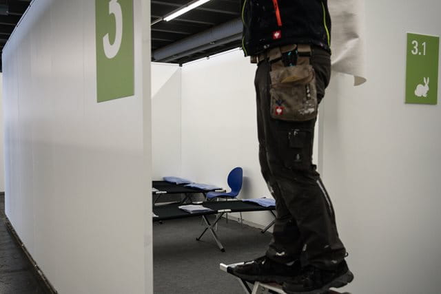 Ein Handwerker in einer Notunterkunft in Frankfurt – hier leben Menschen ohne nennenswerte Privatsphäre auf engstem Raum miteinander.