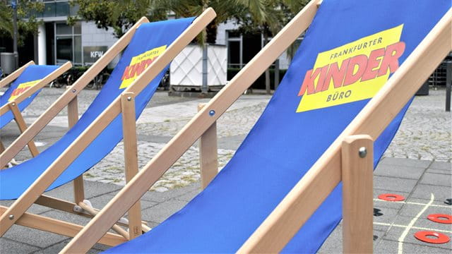 Die blauen Liegestühle des Frankfurter Kinderbüros stehen vor dem Palmengarten.