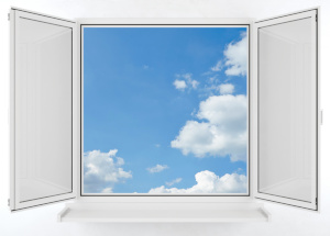 Offenes Fenster mit blauem Himmel und weißen Wolken