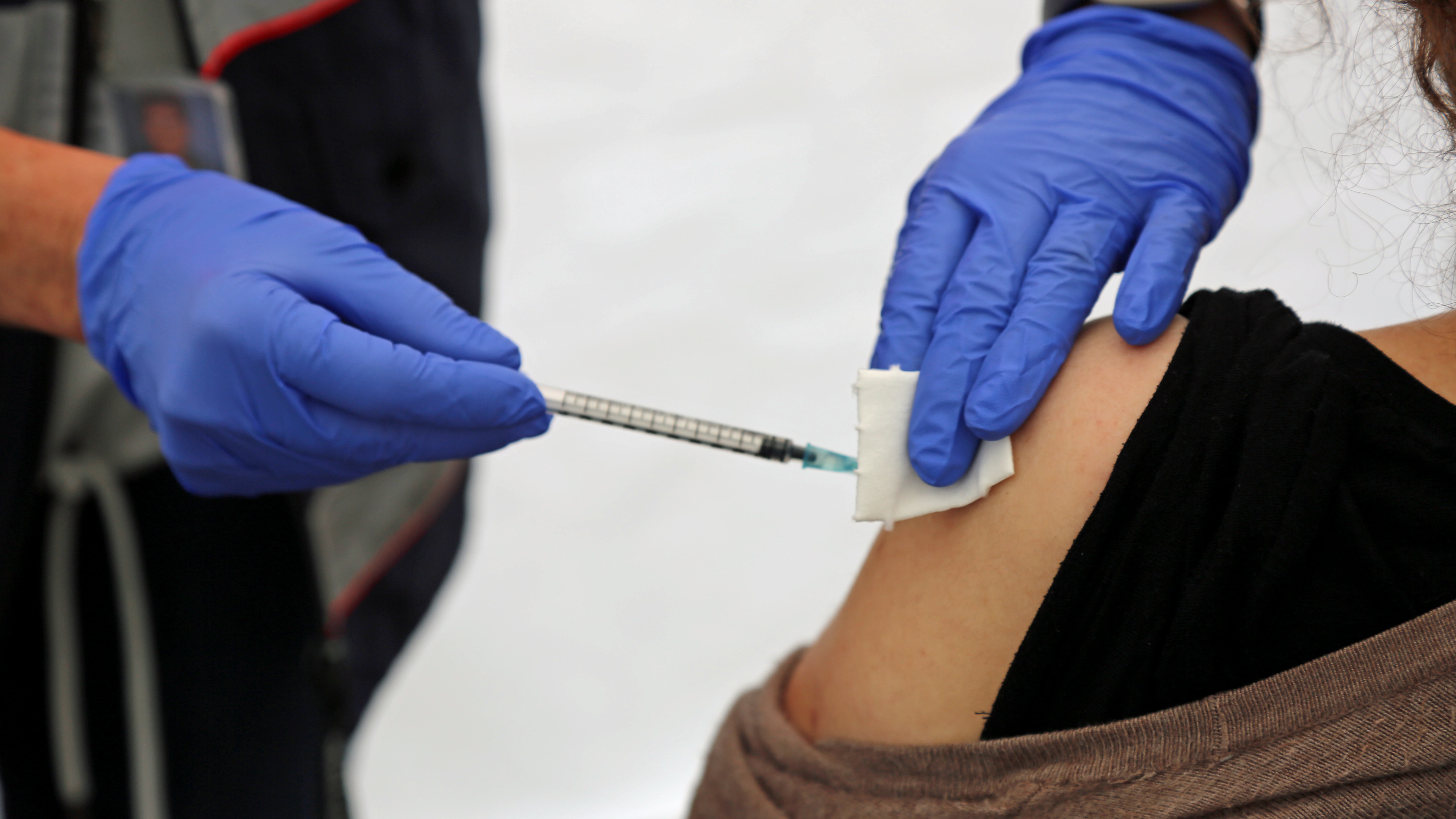 Eine Person wird in den Oberarm mit der COVID-19-Impfung geimpft.
