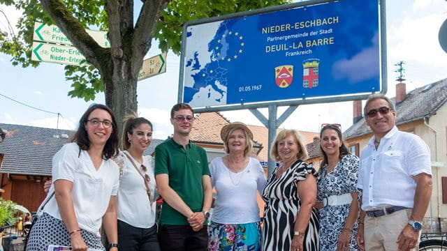 Delegations aus Deuil-La Barre vor dem Städtepartnerschaftsbild in Nieder-Eschbach