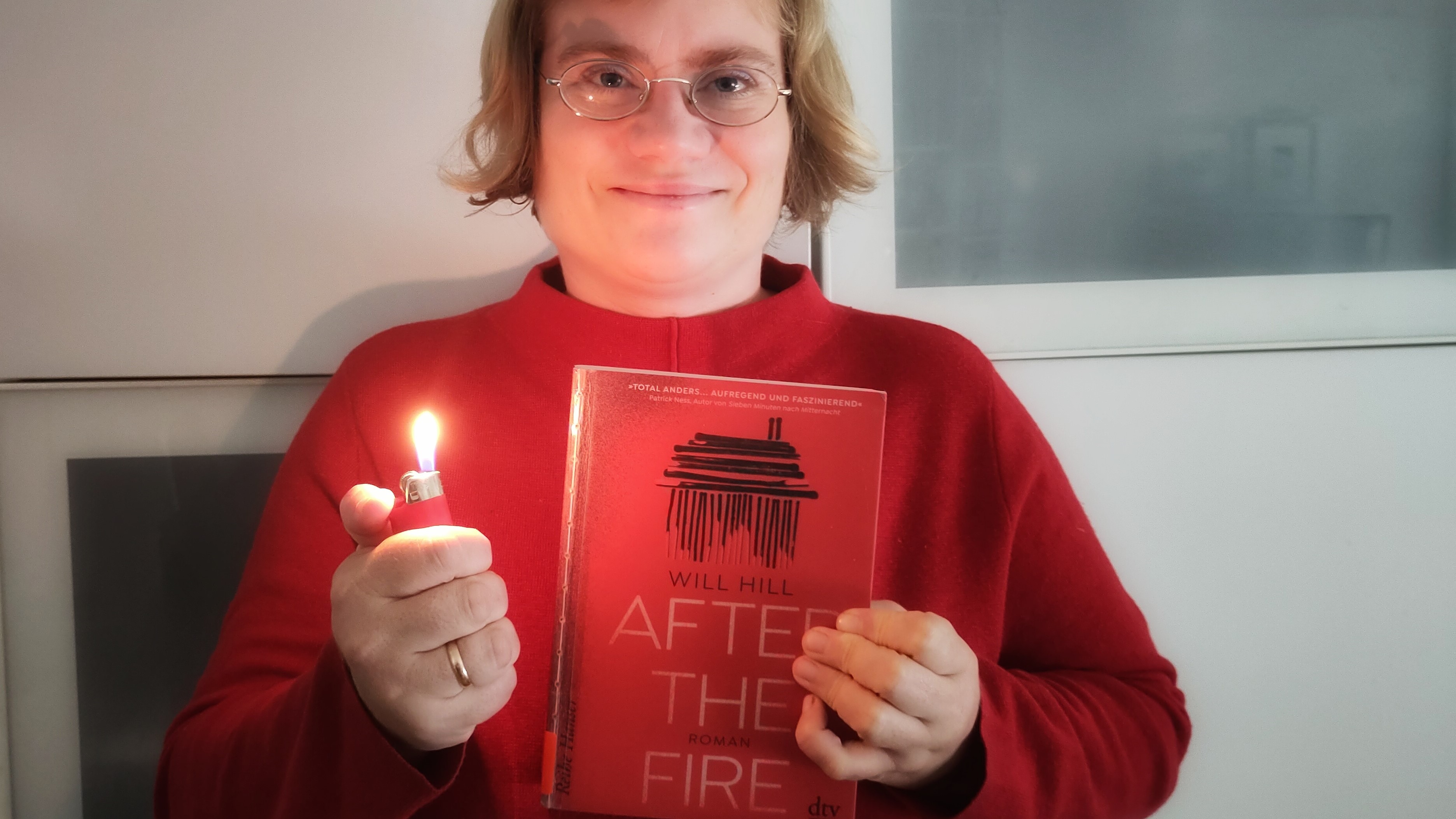 Anna Baumann hält das Buch "After the Fire" und ein Feuerzeug.