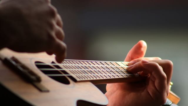 Ukulele – la-la! Eine Person spielt Ukulele
