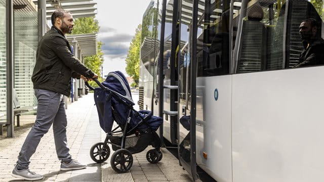A passenger with a stroller gets on the bus, copyright: RMV, photo: Arne Landwehr 