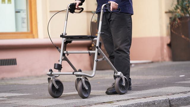 A person with a walker on the sidewalk, copyright: HMWEVW, photo: Corinna Spitzbarth