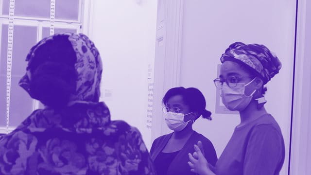 Lila eingetönes Bild von Frauengruppe in Ausstellung mit Maske