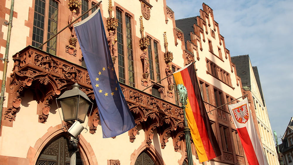 Die Europa-, Deutschland- und Frankfurt-Fahne haengen am Roemer-Balkon in der Innenstadt, (c) Stadt Frankfurt am Main, Foto: Stefan Maurer