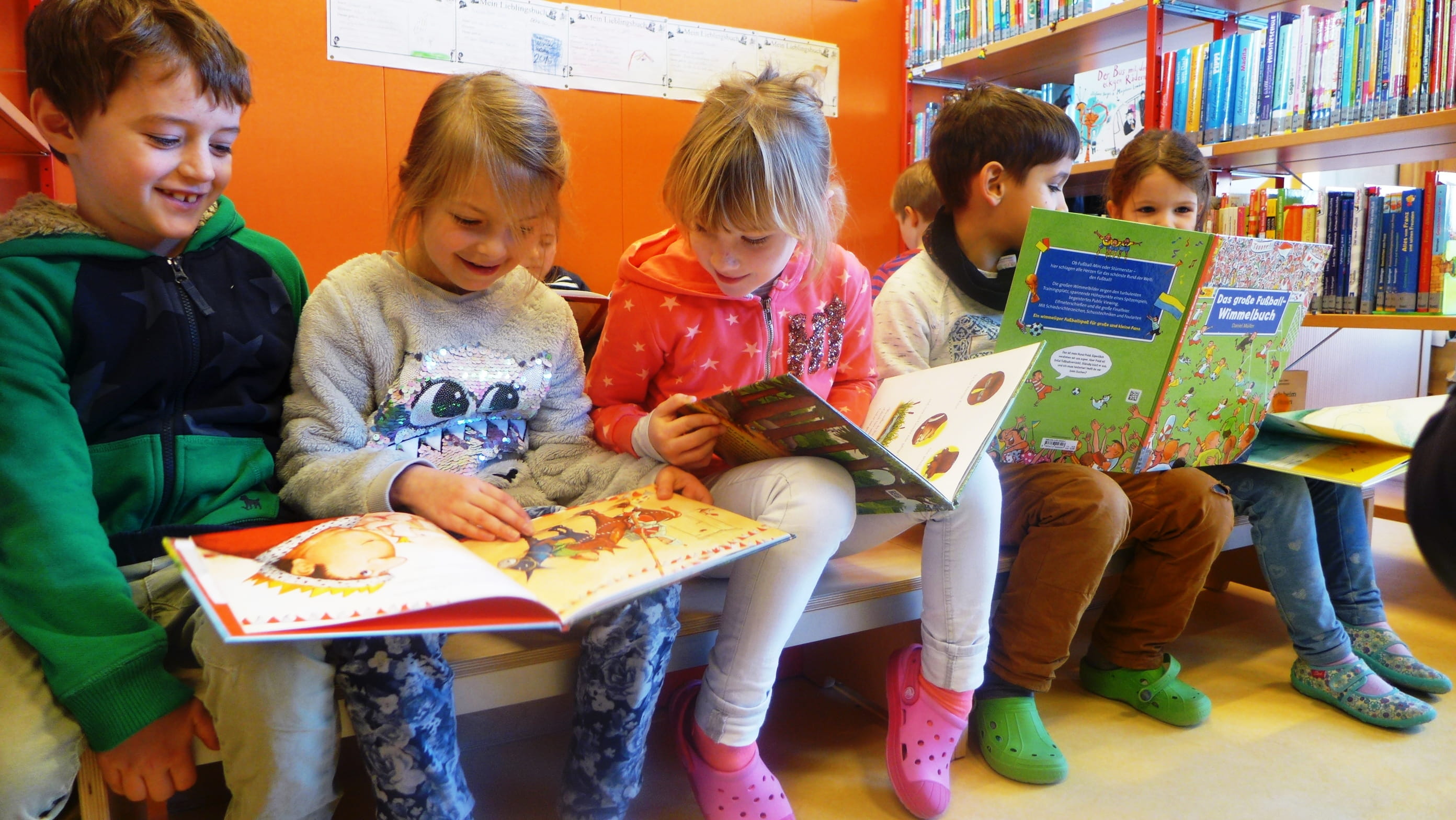 Kinder beim Lesen in der Schulbibliothek der Marie-Curie-Schule